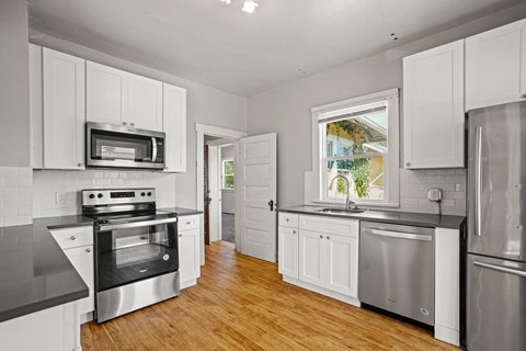 a kitchen with stainless steel appliances and white cabinets